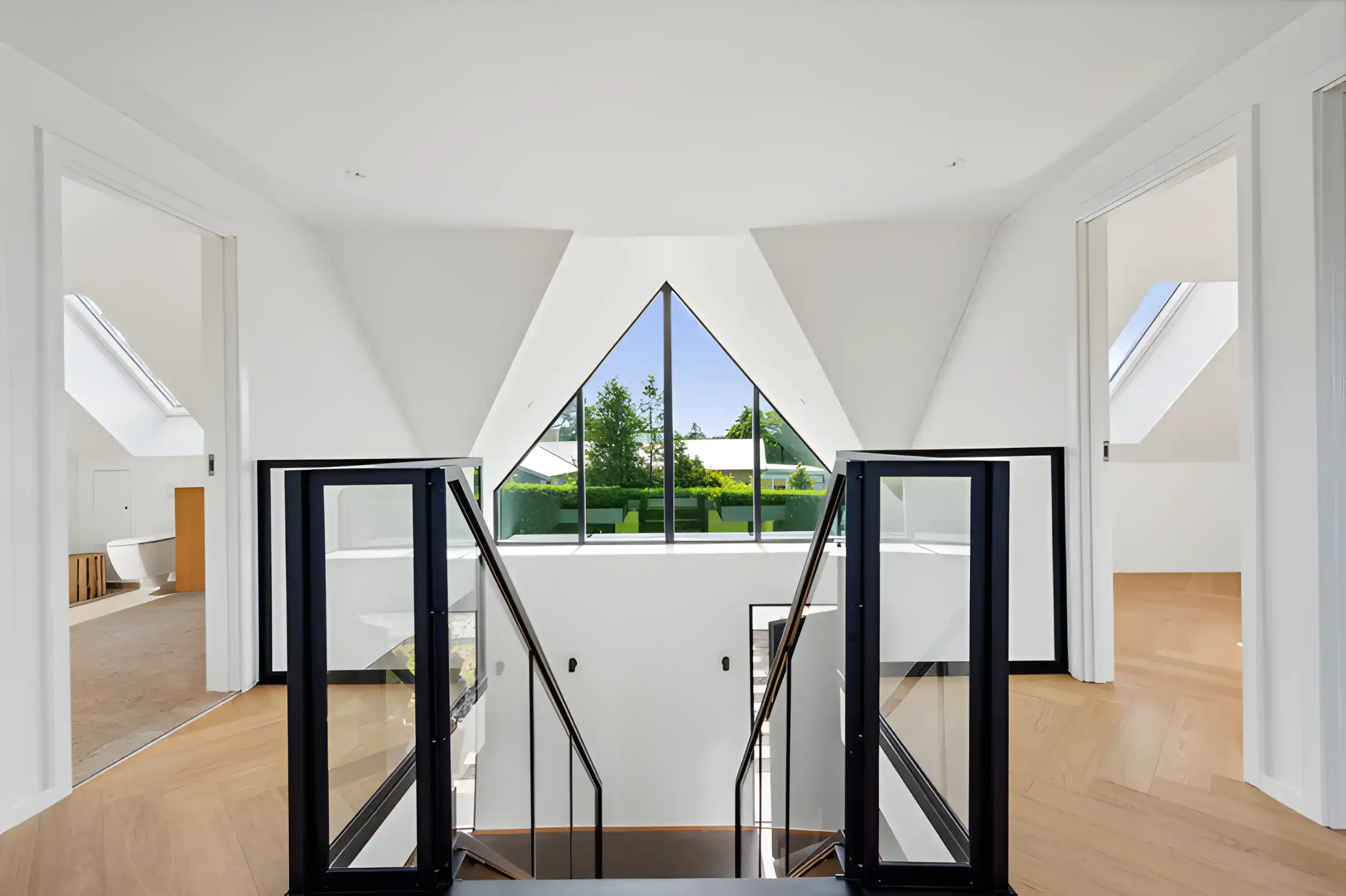 Indendørs trappeområde med store vinduer og naturligt lys.