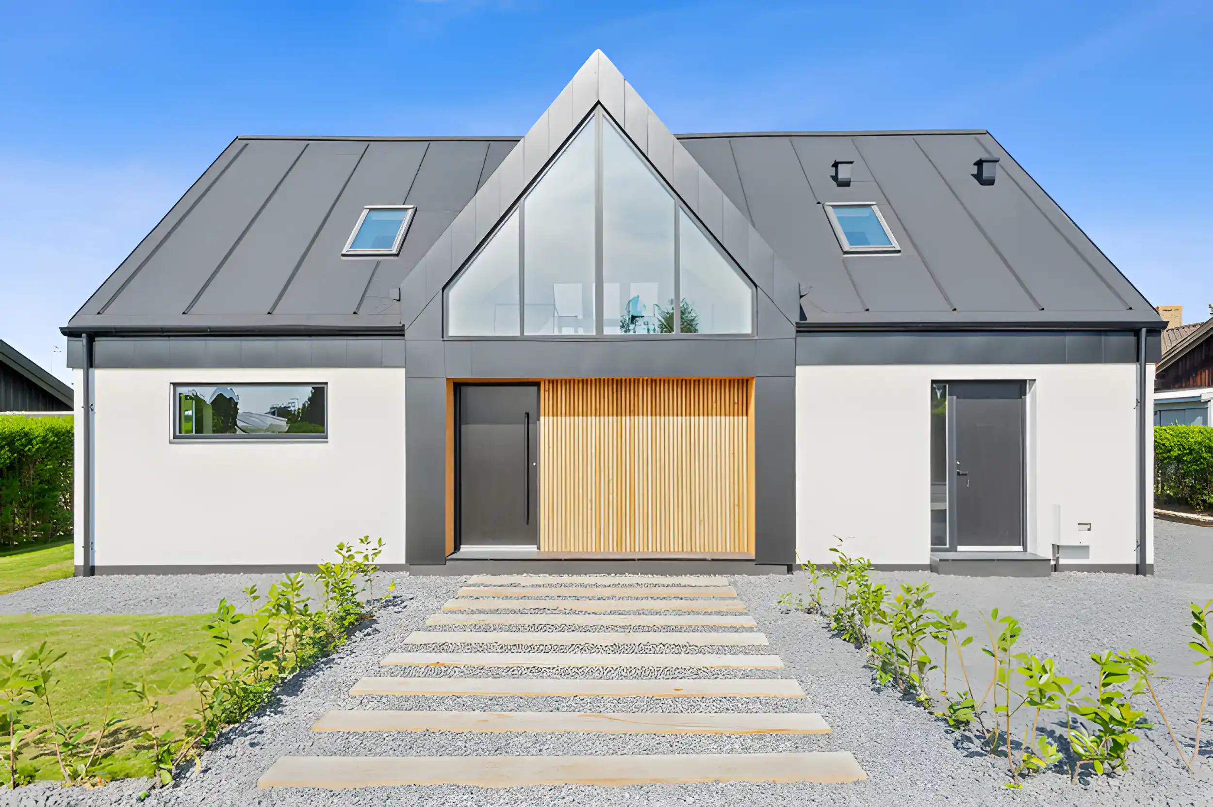 Høj kvalitet moderne bolig med skråtag, store vinduer og minimalistisk design.